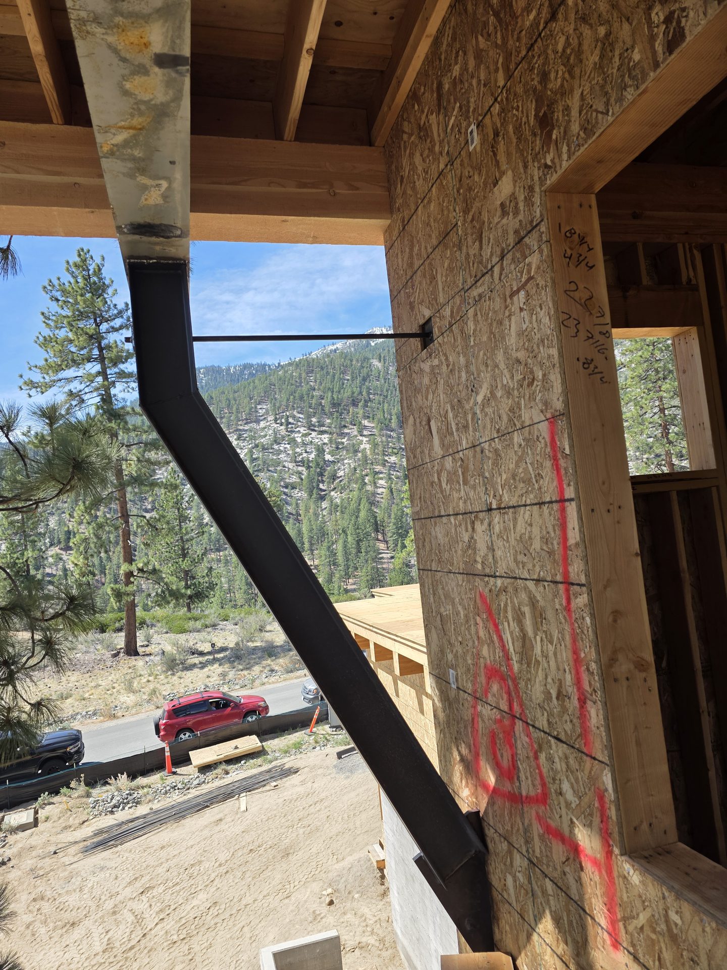 Angular steel column with Sierra Nevada mountain backdrop through custom home opening